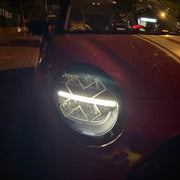 White X headlight decal sticker applied to Mini Cooper front headlights showing comic manga style effect night view