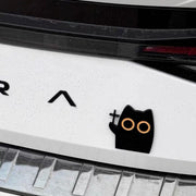 Black cat holding cross metal car decal installed on white trunk
