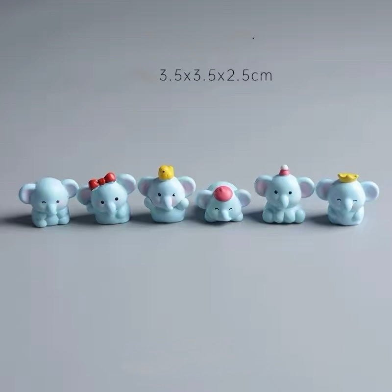 Six cute light-blue mini resin elephant figurines with different accessories (red bow, yellow chick, pink hat, party hat, crown) lined up as car dashboard ornaments