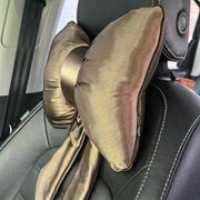 A luxurious golden brown satin bow-shaped car headrest pillow with tails