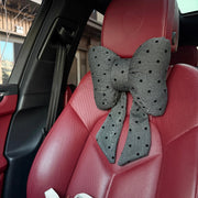 Gray polka dot bow car headrest pillow with tails on red leather car seat