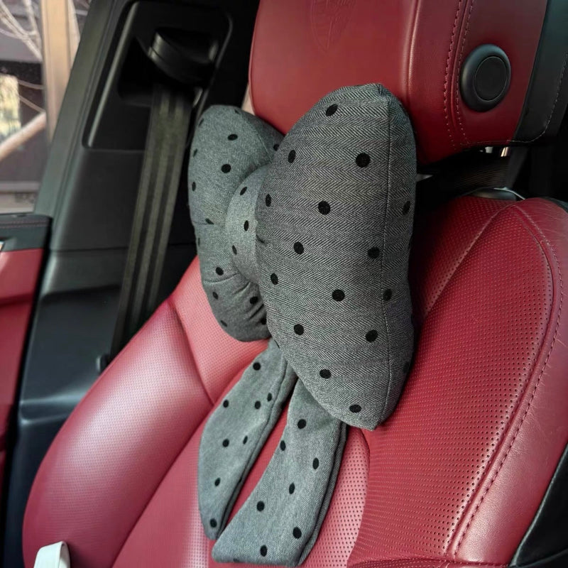 Gray polka dot bow car headrest pillow with tails on red leather car seat