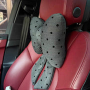 Gray polka dot bow car headrest pillow with tails on red leather car seat