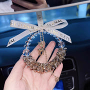 Decorative car hanging with 'Eternal Love is Eternally Love' ribbon held by a hand.